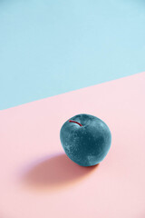 Blue apple on a pink and blue background