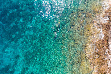 Drone photo of diving in crystal clear sea near village of Stomorska on Šolta Island in Croatia in summer