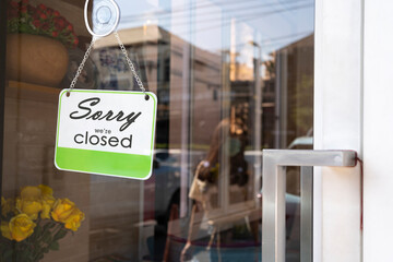 Sorry we're closed sign board hanging on door of cafe.