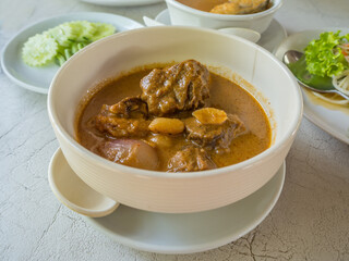 yellow curry beef in thai cuisine style in a bow on a table