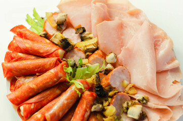 A cold plate prepared for the party with sliced chorizo, ham and sausages