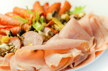 A cold plate prepared for the party with sliced chorizo, ham and sausages