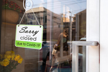 A business sign that says ‘Sorry, We're Closed’ on glass door.