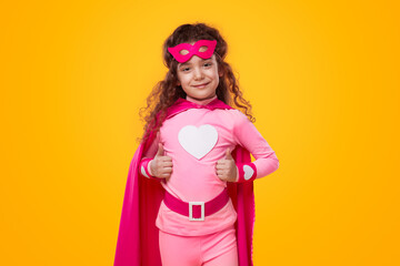 Delighted superhero kid showing thumbs up