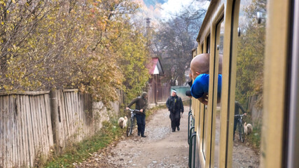 Passengers leaned out of the windows of the steam train Mocanita, Romania