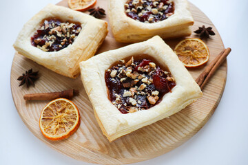 puff with jam and nuts on a wooden table. frozen pastry. 
