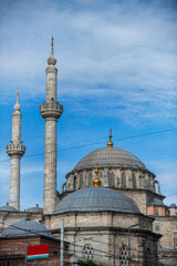 Fototapeta na wymiar Facade of an old mosque in Istanbul built in stone and zinc domes and two minarets of call to prayer