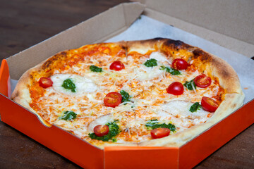 Fresh homemade Italian pizza  with mozzarella and basil in the box