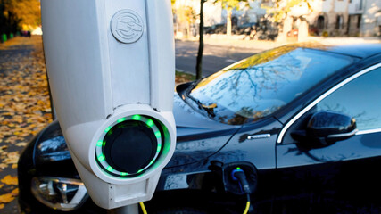 Charging car at a charging station in autumn