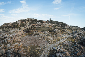 Naklejka premium Kullaberg lighthouse on the rocky coast at Kullaberg nature reserve in south Sweden. Popular tourist destination for hiking.