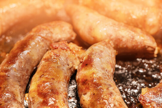 Fried homemade sausages in a frying pan
