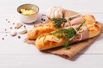 Baguette with garlic butter and herbs, fried, on a white wooden table, no people,