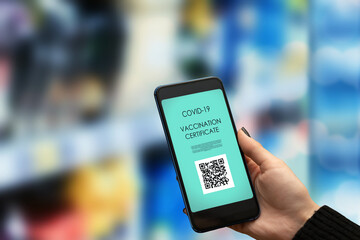 vaccination passport for a grocery store,hand with a phone with a qr code certificate for proof of...