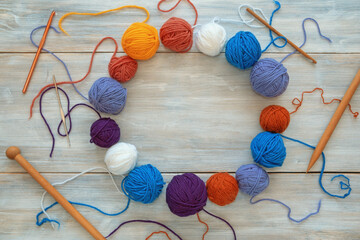 Hobby and knitting concept. Colorful balls of wool, knitting needles and  crochet hooks on rustic...