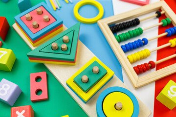 Multicolored wooden blocks on red background. Trendy puzzle toys. Geometric shapes: square, circle,...