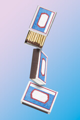 Falling open and closed matchbox on blue and pink background