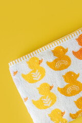 Baby towel with cute ducks on yellow background.