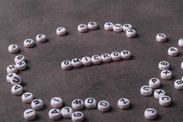 the words covid, omicron, are written in letters on a gray background. there are a lot of toy inscriptions nearby.