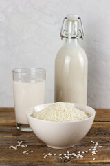 A bottle and a glass with dairy free rice milk and seeds in a bowl