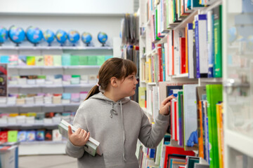  12-year-old girl between   bookshelves in   store