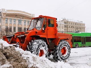 Obraz na płótnie Canvas Tractor removes snow from the street