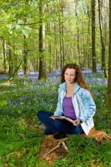 Woman reading in wildflower forest