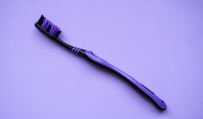 Purple toothbrush on a lilac background. Close-up.