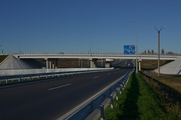 Dusk colored clouds in the background, highway overpass curved approach bridge