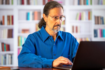 Angry stressed businessman reading bad news on laptop. Mad man feels frustrated about high bills, dismissal notice, bank debt, tax invoice or mistake sits at home office desk.