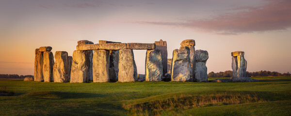 Panorama of the prehistoric site of Stonehenge during early morning. beautiful orange glow on the stones - obrazy, fototapety, plakaty