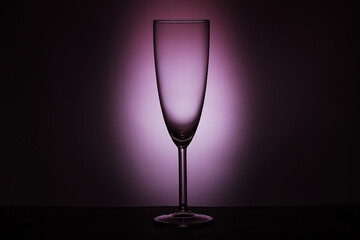 Champagne glass on purple background. Luxury drink glass in purple lights. Low Key. Copy space, isolate, selective focus