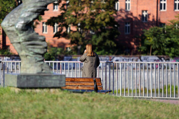 Kobieta rozmawia przez telefon, spacerując ulicami Wrocławia.