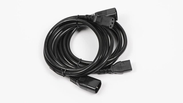 Two black power cord C13-C14 connector, on white. Side view. Loop motion. Rotation 360. 4K UHD video footage 3840X2160.