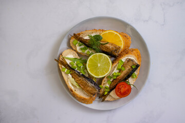 sprats in a can, fresh dill on wooden background