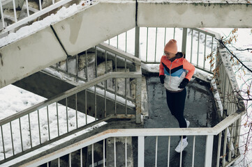 Young woman running on the stairs in the winter.