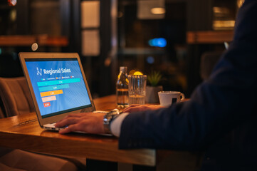 Businessman working on his laptop while drinking coffee in a cafe
