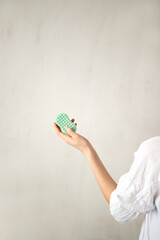 The girl holds a mint-colored soap in her hand, on a white background