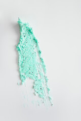 The mint-colored scrub is smeared in a wide patch on a white background.