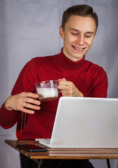 man, in casual clothes, sitting with a laptop, talking on Skype, looking at a laptop screen