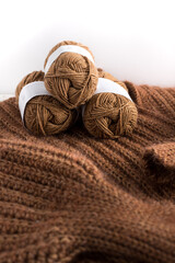 Obraz na płótnie Canvas Three warm wool yarns piled over a crochet mohair wool jacket.