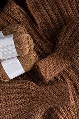 Warm mohair and wool jacket with their sleeves and a pile of yarns over it.