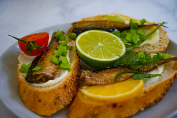 sprats in a can, fresh dill on wooden background