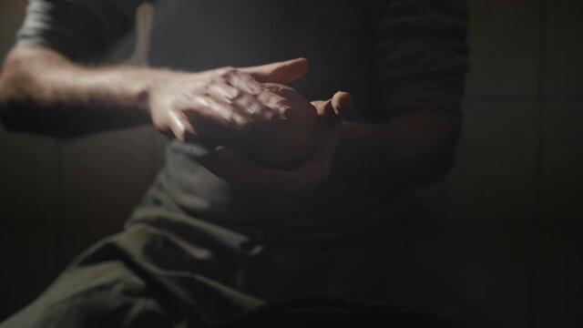 Artisan male hands crumple clay in slow motion