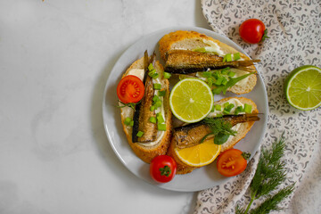 sprats in a can, fresh dill on wooden background