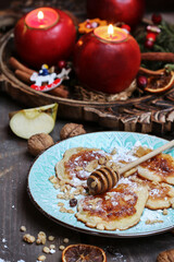 Apple fritters with powdered sugar, honey and muesli.