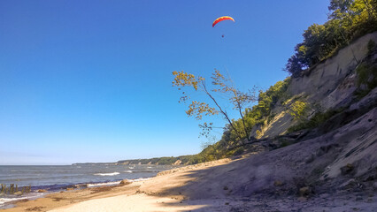 A paraglider flies over the wild beach of the Baltic Sea