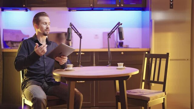 Host on live podcast introduce empty seat guest for round table discussion 4K