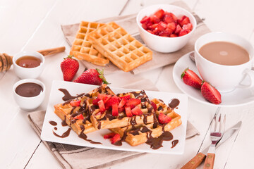 Waffles with strawberries and chocolate cream.