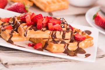 Waffles with strawberries and chocolate cream.