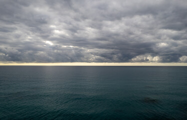 Obraz premium Stormy clouds with dramatic sky above the sea at sunset